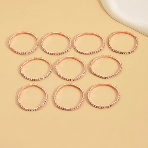 Close-up of ten rose gold stackable rings featuring clear round cubic zirconia stones