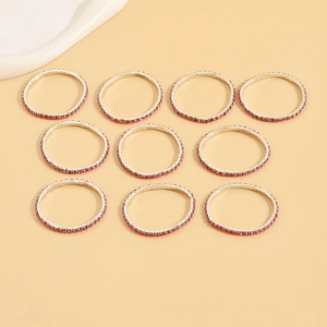 Detailed macro view of 10-piece set of silver rings with pink zircon stone settings
