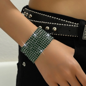 Close-up of wide multi-layer dark green rhinestone bracelet on wrist for formal occasions