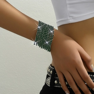 Macro detail of multi-row wide stretch bracelet with deep green rhinestones on wrist