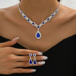 Elegant silver-toned jewelry set with pear-cut blue sapphire and sparkling crystal accents