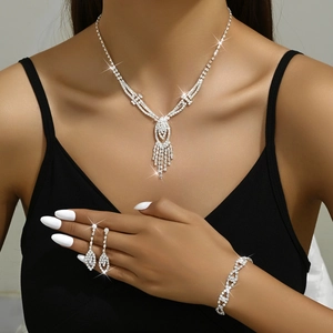 Close-up of V-shaped rhinestone fringe necklace and teardrop earrings on model