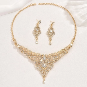 Detail view of a vintage gold bridal jewelry set with sparkling rhinestones and ornate swirls