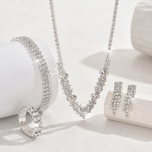 Elegant four-piece bridal jewelry set with sparkling rhinestones on minimalist silver base
