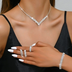 Close-up of sparkling bridal jewelry set including V-shaped necklace and drop earrings