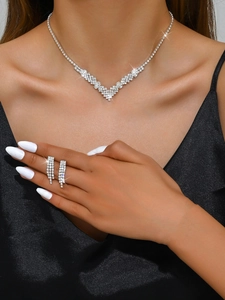 Sparkling crystal V-shaped necklace and drop earrings set worn on elegant black silk fabric
