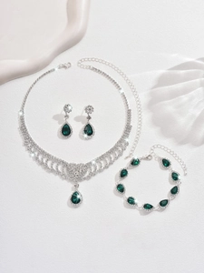 Detailed view of emerald waterdrop fringe necklace and earrings set with white crystals