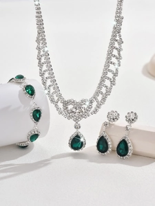 Detailed macro of water-drop emerald green gems and silver diamond fringe jewelry set