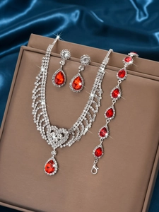 Detail of red teardrop gemstone necklace set with rhinestones on blue silk background