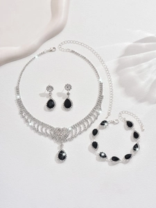 Macro shot of silver-plated jewelry set with black teardrop gemstones and crystal fringe