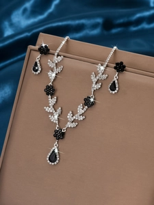 Gros plan d'une parure de bijoux de mariée avec collier floral et boucles d'oreilles