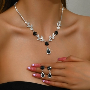 Détail d'un ensemble collier floral et boucles d'oreilles avec cristaux noirs sur mannequin