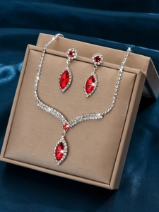 Macro view of bridal jewelry set with red marquise stones in a champagne gift box