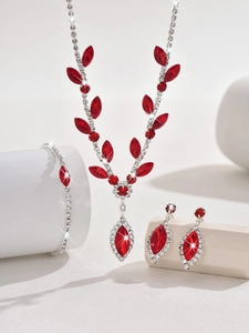 Macro detail of the V-shaped silver bridal necklace set with red marquise crystals