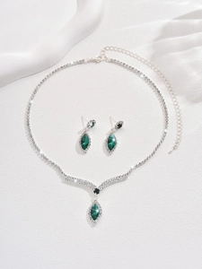 Detailed macro view of bridal jewelry set with green marquise gems and sparkling rhinestones