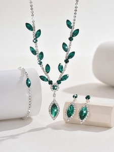 Detailed view of silver necklace and emerald leaf jewelry set with marquise cut stones