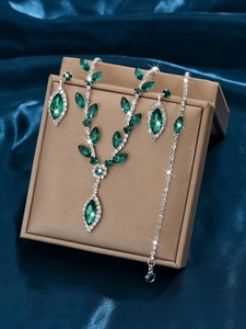 Close-up of sparkling bridal jewelry set with green gemstones and white rhinestones