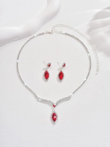 Detail of bridal jewelry set with red marquise gemstones and sparkling rhinestones