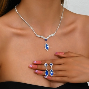 Close-up of royal blue V-shaped necklace and drop earrings set on model
