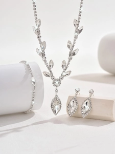 Detailed view of silver bridal jewelry set with sparkling crystals on white blocks