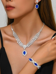 Detailed close-up of luxury sapphire blue jewelry set with necklace and earrings on model