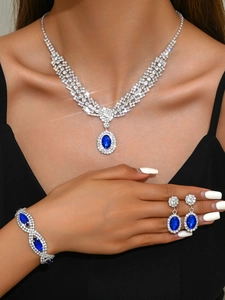Luxurious sapphire jewelry set featuring a necklace, bracelet and drop earrings on a model