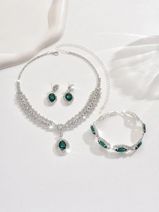Macro shot of silver jewelry set with oval green gemstones and sparkling rhinestones