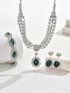 Macro detail of emerald green gemstone jewelry set including necklace and bracelet