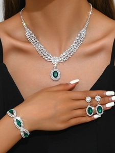 Detailed view of luxury silver-tone jewelry set with oval green emerald-style gemstones