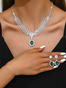Macro detail of luxury silver jewelry set with oval green emeralds and crystals