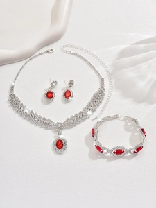 Detailed view of luxury silver-tone jewelry set featuring red oval gems and sparkling rhinestones