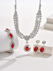 Detailed view of luxury silver-tone jewelry set with oval red rubies and sparkling crystals