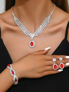 Close-up of luxury bridal jewelry set with red ruby gems and silver-tone crystals