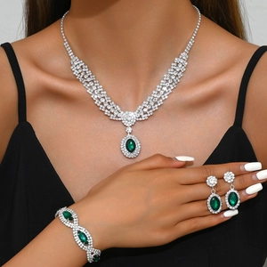 Luxury silver-tone jewelry set with deep green sapphire-style oval stones and diamonds