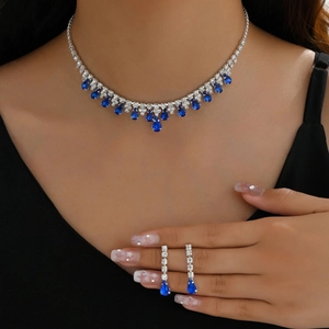Elegant silver necklace and drop earrings set with deep blue teardrop gemstones