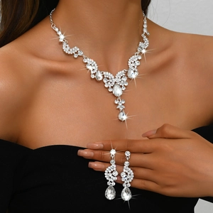 Close-up of bridal jewelry set featuring teardrop crystals and silver metal texture