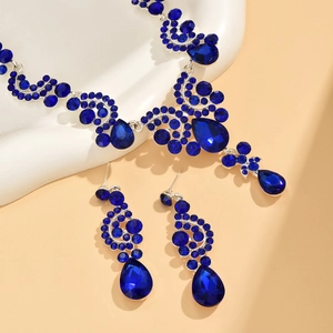 Detail of luxury bridal jewelry set with royal blue teardrop gems and silver necklace
