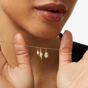 Elegant gold aventurine shell and pearl necklace shown on a model neck profile