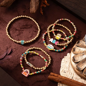 Detailed shot of golden beaded charm bracelets with colorful school themed pendants