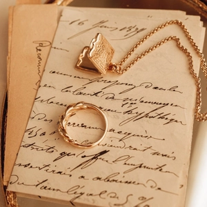 Dettaglio della collana con medaglione quadrato vintage e anello a corda lucido