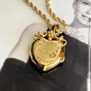 Dettaglio della collana con medaglione dorato e incisione A TOKEN OF LOVE e angelo