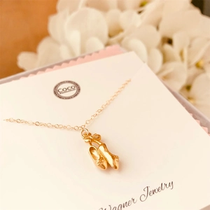 Élégant collier doré avec pendentif chaussons de danse et nœud sur carte cadeau