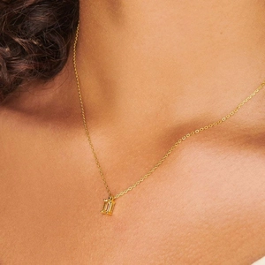 Close-up of 18K gold plated titanium necklace with rectangular zircon pendant on neck