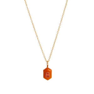 Detail of a gold-plated hexagonal pendant with orange stone and a center red crystal