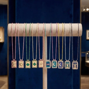Macro detail of Bohemian tarot square pendants with colorful enamel and stone borders