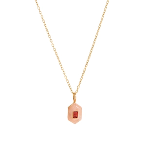 Gold hexagon pendant necklace with pink enamel and red crystal stone on white background