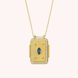 Detail of rectangular tarot pendant with blue marquise gem and gold bead texture