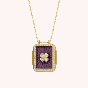 Detailed macro of gold tarot pendant with purple sunburst and diamond clover