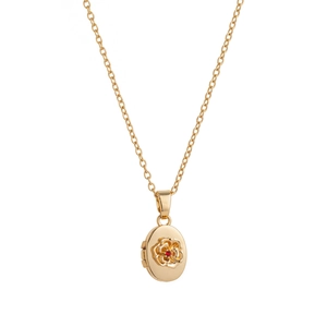 Detalle de relicario ovalado dorado vintage con rosa en relieve y piedra roja