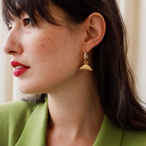 Détail de créoles en or 18 carats avec pendentif croissant portées par un mannequin